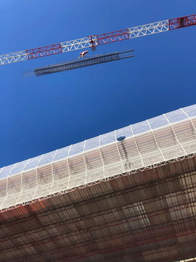 Un fascio di barre sollevato dalla gru contro il cielo